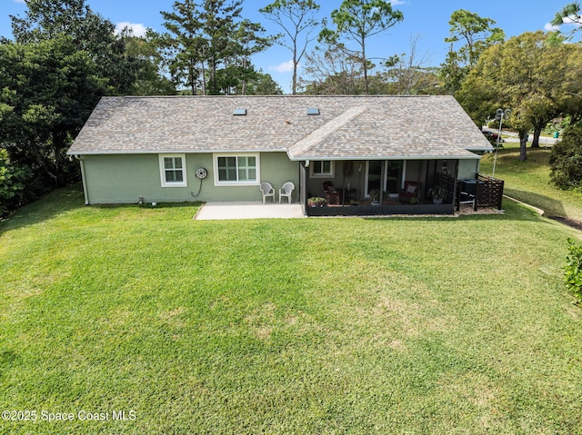 back of house featuring a lawn, a sunroom, and a patio area