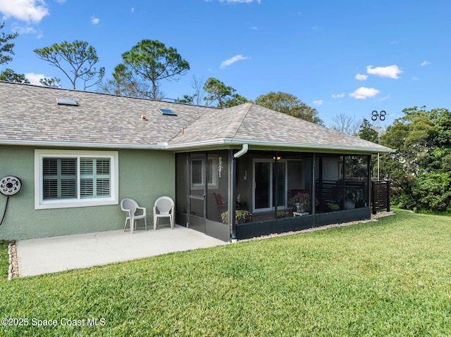 rear view of property featuring a sunroom, a patio area, and a lawn