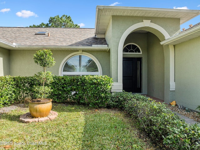 property entrance featuring a lawn