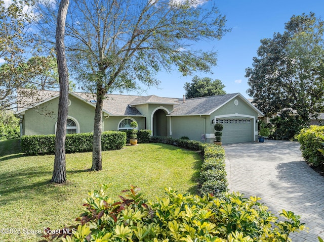 ranch-style home featuring a garage and a front lawn