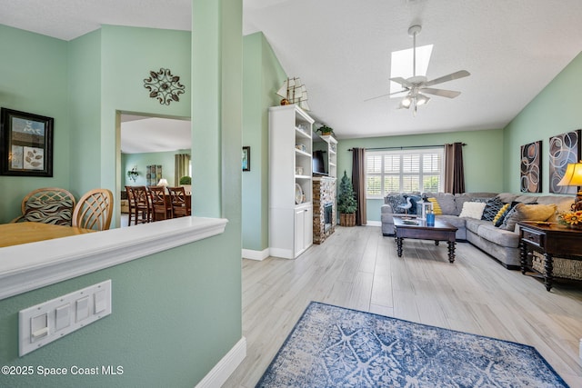 living room with ceiling fan, a textured ceiling, and hardwood / wood-style flooring