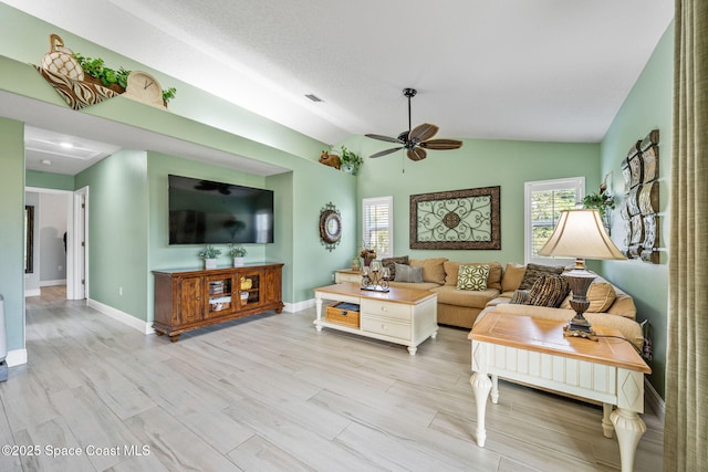 living room with light hardwood / wood-style floors, ceiling fan, and lofted ceiling