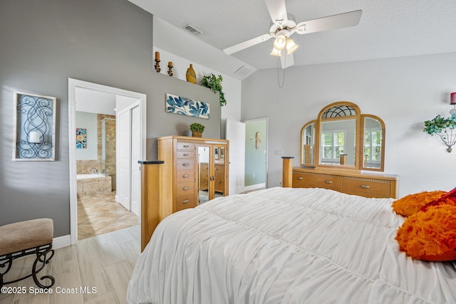 bedroom with a textured ceiling, ensuite bathroom, ceiling fan, and vaulted ceiling