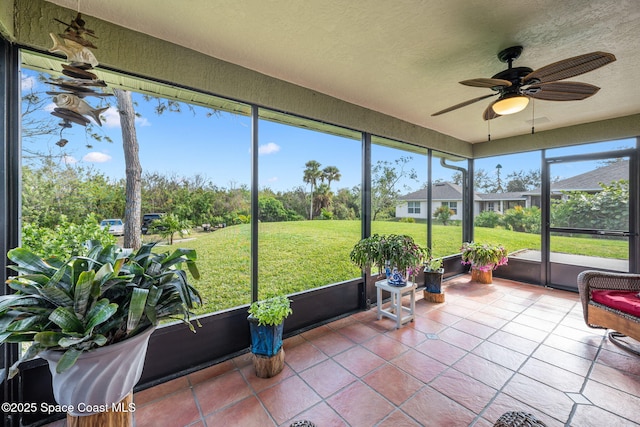 sunroom featuring ceiling fan and plenty of natural light