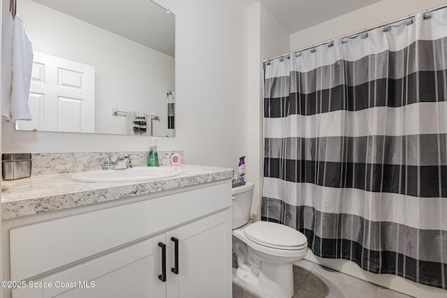 bathroom featuring vanity, a shower with shower curtain, tile patterned flooring, and toilet