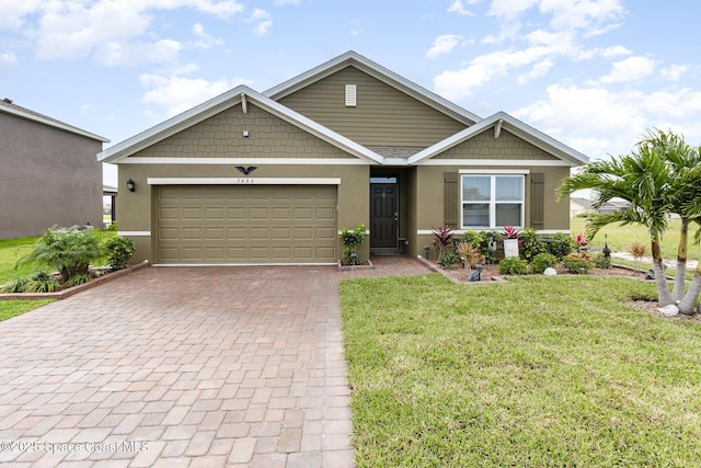 view of front of property with a front yard, decorative driveway, an attached garage, and stucco siding