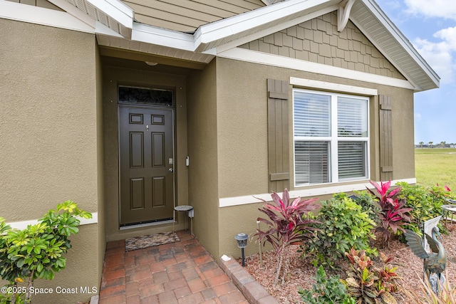 doorway to property featuring stucco siding