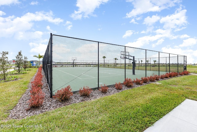 view of tennis court featuring community basketball court, a lawn, and fence