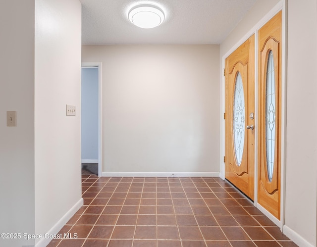 tiled entryway with a textured ceiling