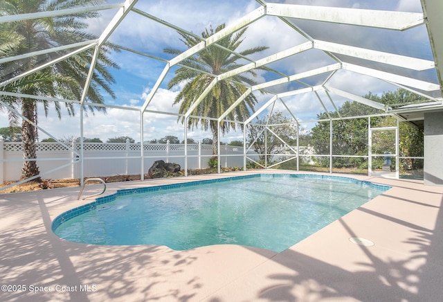 view of swimming pool featuring a patio area and glass enclosure