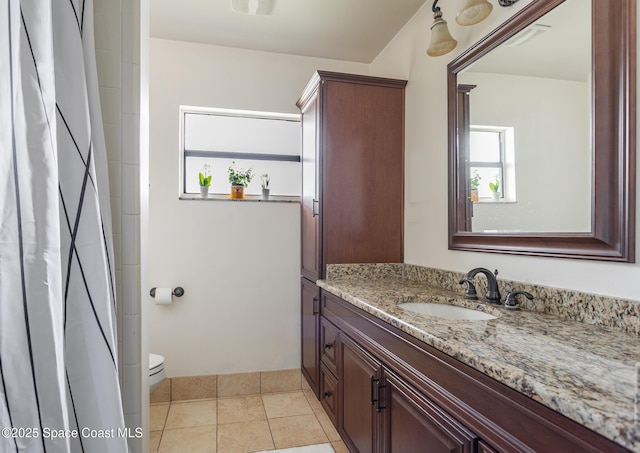 bathroom featuring tile patterned flooring, vanity, and toilet