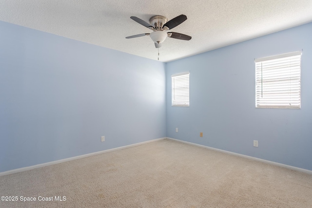 carpeted spare room featuring ceiling fan and a textured ceiling