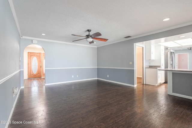 unfurnished living room featuring dark hardwood / wood-style flooring, crown molding, a textured ceiling, and ceiling fan