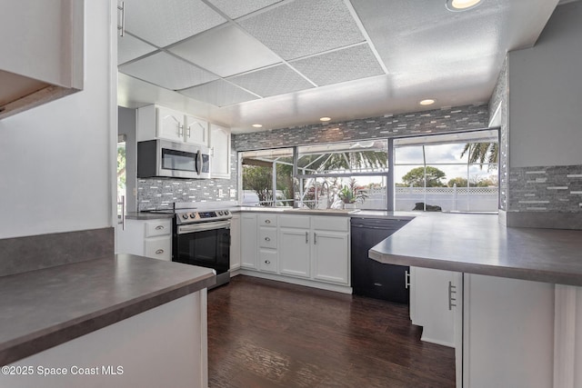 kitchen featuring white cabinetry, appliances with stainless steel finishes, dark wood-type flooring, and a wealth of natural light