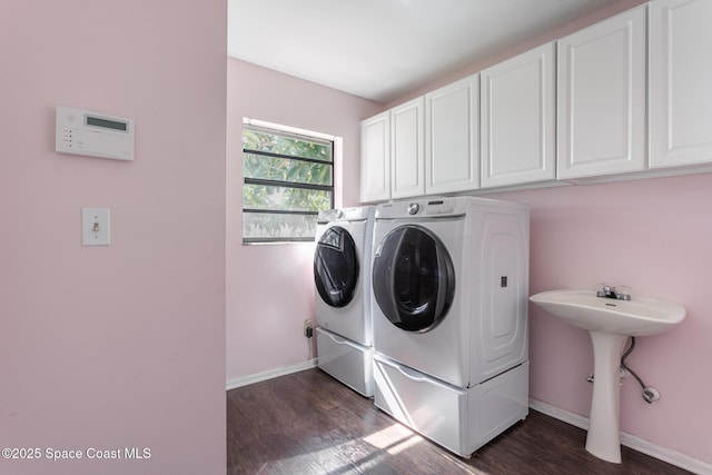 washroom featuring cabinets, separate washer and dryer, sink, and dark hardwood / wood-style flooring