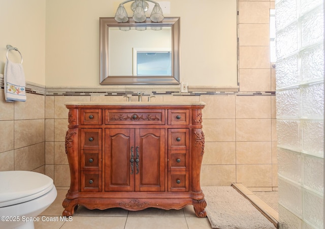 bathroom with tile walls, vanity, tile patterned floors, and toilet