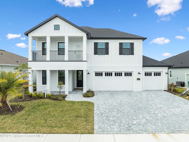 view of front of property featuring a balcony, cooling unit, and a front yard