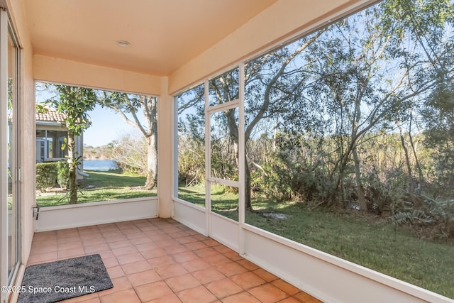 unfurnished sunroom featuring a water view