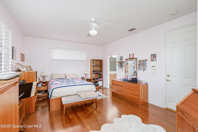 bedroom with hardwood / wood-style flooring, ceiling fan, and ensuite bath