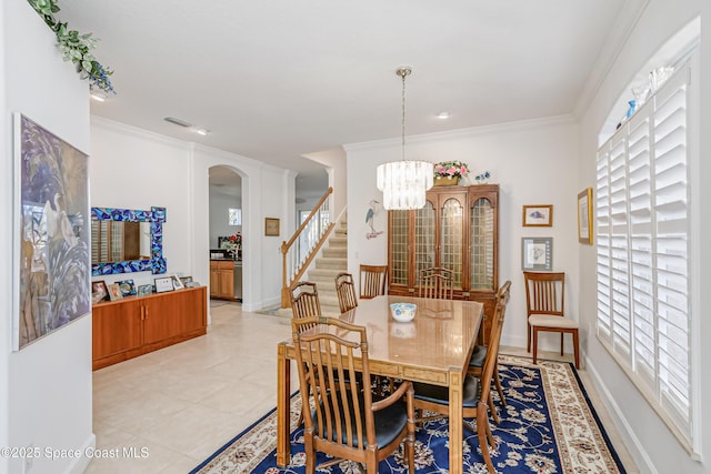 tiled dining room with an inviting chandelier and ornamental molding