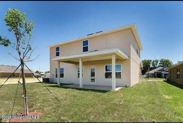 rear view of house featuring central AC unit, a patio, and a lawn