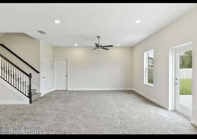 unfurnished living room featuring light carpet and ceiling fan