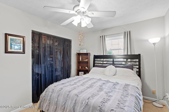 tiled bedroom featuring a textured ceiling, a closet, and ceiling fan