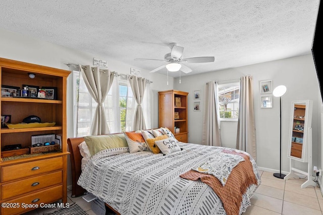 tiled bedroom featuring ceiling fan and a textured ceiling