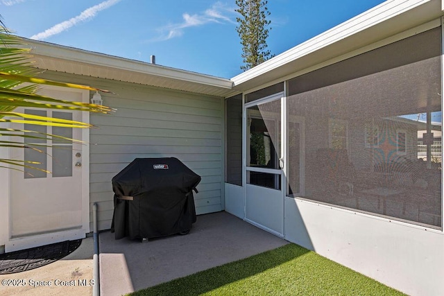 view of patio / terrace with a sunroom and a grill