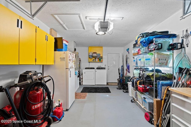 garage with washing machine and dryer, white fridge, and a garage door opener