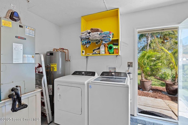 clothes washing area featuring electric water heater, independent washer and dryer, and heating unit