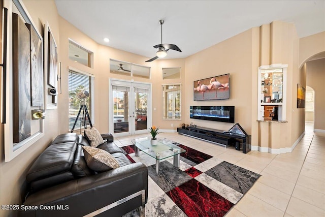 tiled living room featuring ceiling fan and french doors