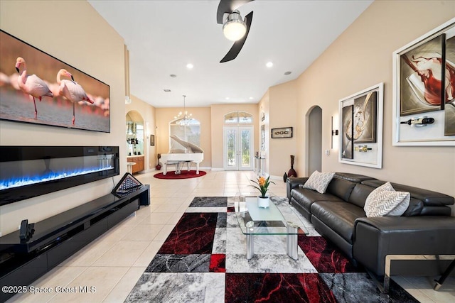 living room with ceiling fan with notable chandelier, light tile patterned floors, and french doors