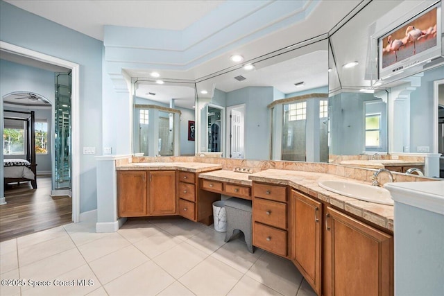 bathroom with tile patterned floors, a shower with door, and vanity