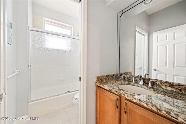 full bathroom with tile patterned flooring, toilet, combined bath / shower with glass door, and vanity