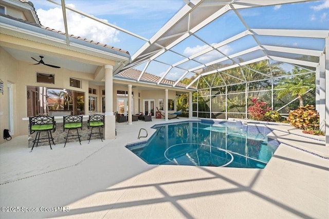 view of swimming pool with french doors, exterior bar, ceiling fan, a lanai, and a patio area