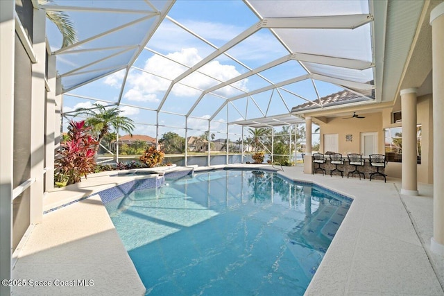 view of pool featuring a patio, glass enclosure, and ceiling fan