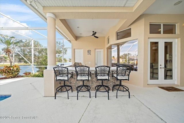 view of patio / terrace with a lanai, outdoor dry bar, and french doors