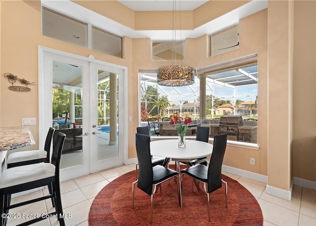 dining area featuring light tile patterned floors, baseboards, a sunroom, and french doors