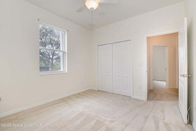 unfurnished bedroom with ceiling fan, a closet, and light carpet