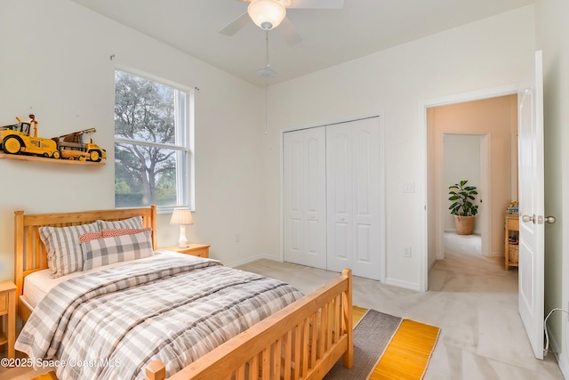 carpeted bedroom with ceiling fan and a closet