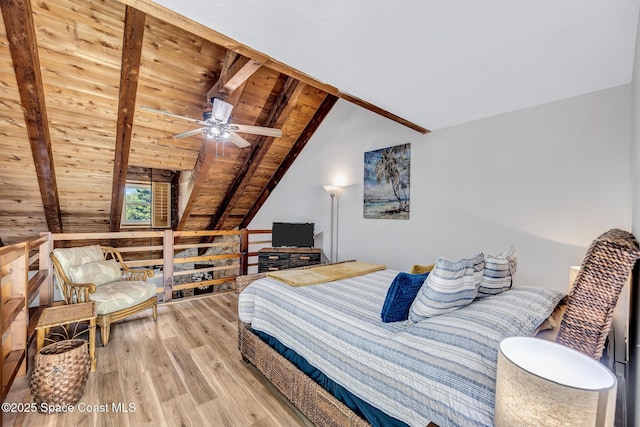 bedroom with wood walls, wooden ceiling, lofted ceiling with beams, ceiling fan, and light hardwood / wood-style floors