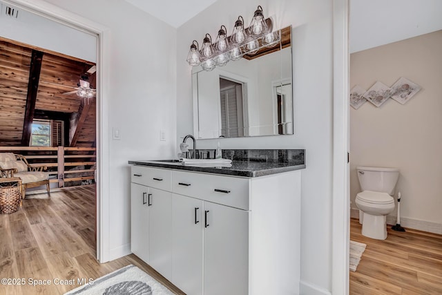 bathroom with vanity, ceiling fan, toilet, and wood-type flooring