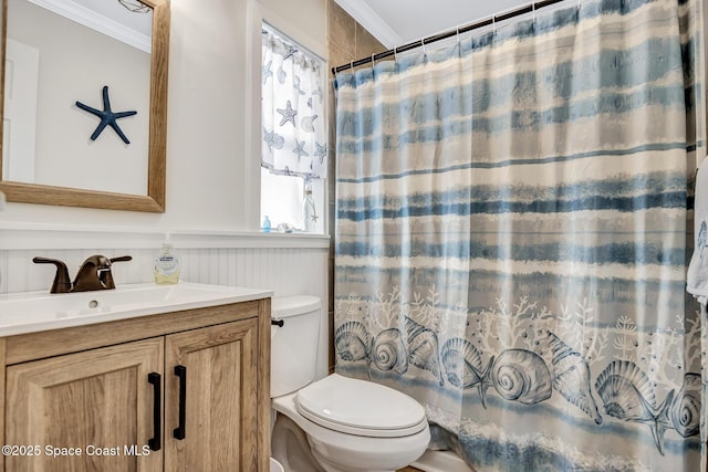 bathroom with vanity, toilet, walk in shower, and crown molding