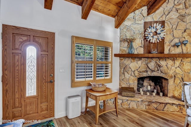 entrance foyer with beam ceiling, a wealth of natural light, a fireplace, and hardwood / wood-style floors