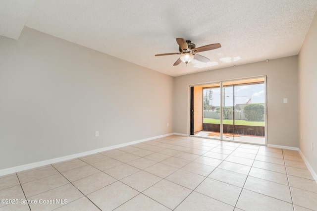 tiled empty room with ceiling fan and a textured ceiling