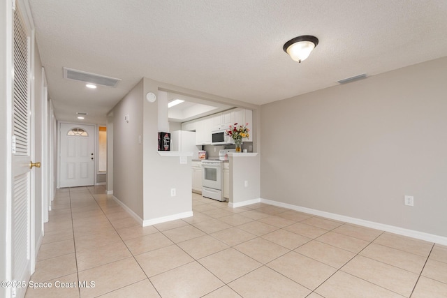 interior space with a textured ceiling and light tile patterned floors