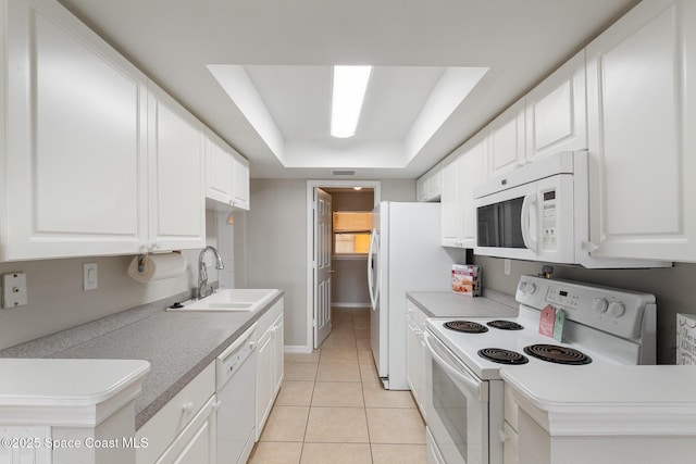 kitchen featuring white appliances, a raised ceiling, sink, and white cabinets