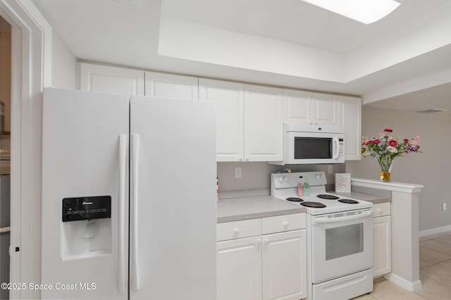 kitchen featuring light tile patterned flooring, white cabinets, and white appliances