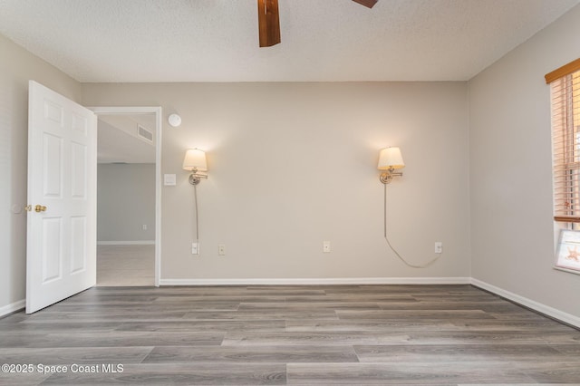 unfurnished room with wood-type flooring, plenty of natural light, and a textured ceiling